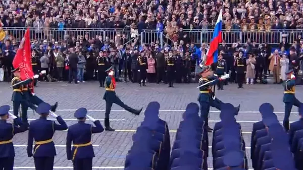 俄軍旗手在《神聖的戰爭》軍樂聲中高舉俄羅斯國旗和勝利旗入場。(俄羅斯衛星通訊社)