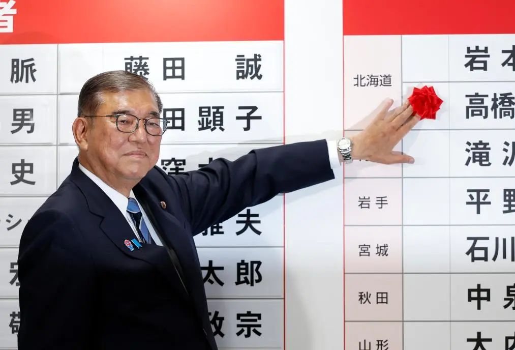 7月20日，在日本東京自民黨總部，日本首相、自民黨總裁石破茂為當選議員貼花。（新華社資料圖片）