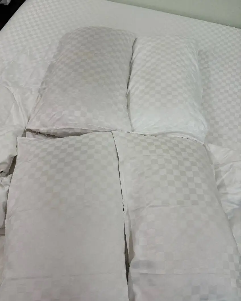 客房的床單上沾著不明淺褐色污漬，被單邊角還起了毛球，最離譜的是枕套，不僅泛著油膩的黃色，邊緣甚至能看到細小的污漬殘跡，一眼就看出長時間沒認真清潔！（來源：爆废公社/FB）