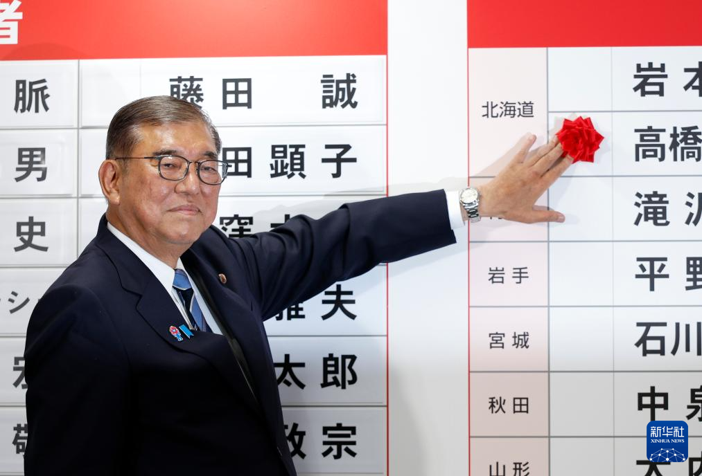 7月20日，在日本東京自民黨總部，日本首相、自民黨總裁石破茂為當選議員貼花。新華社發（Pool圖片，弗蘭克·羅比雄攝）